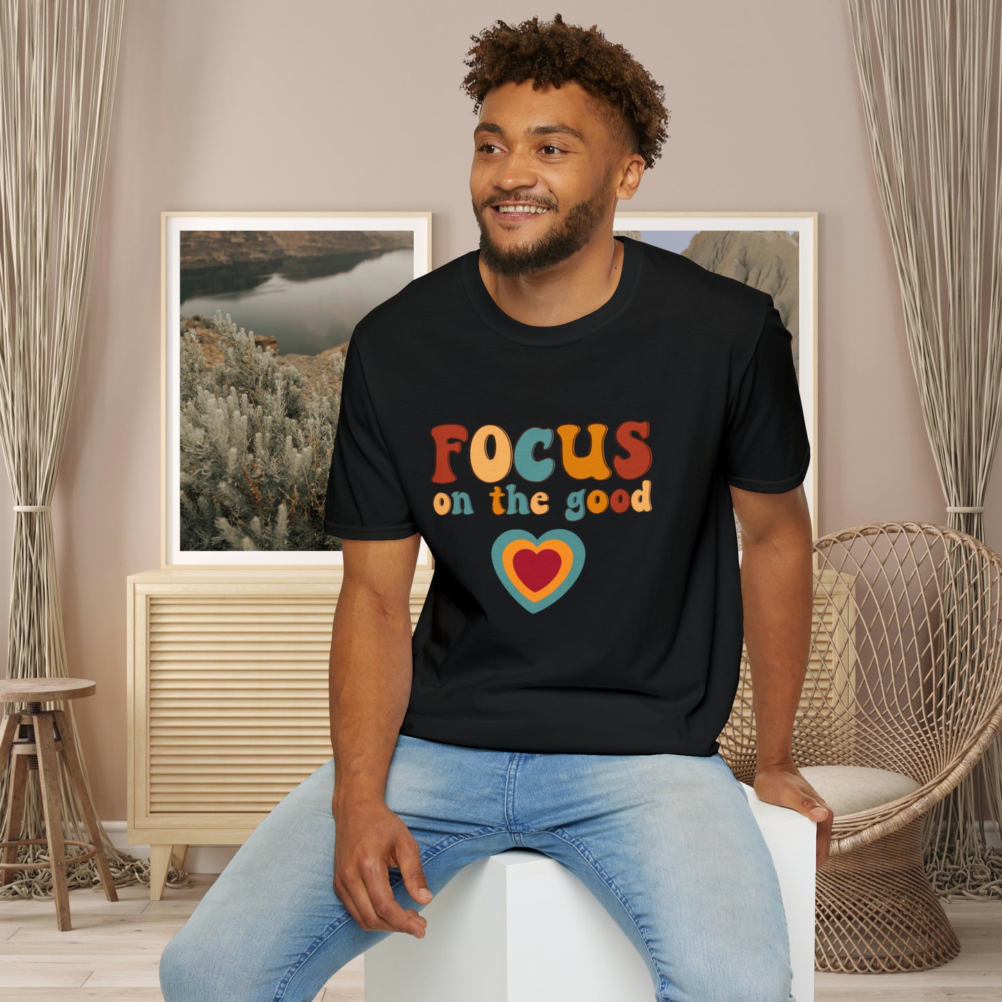 “FOCUS on the good” above a multicolored heart on this Unisex Softstyle T-Shirt.