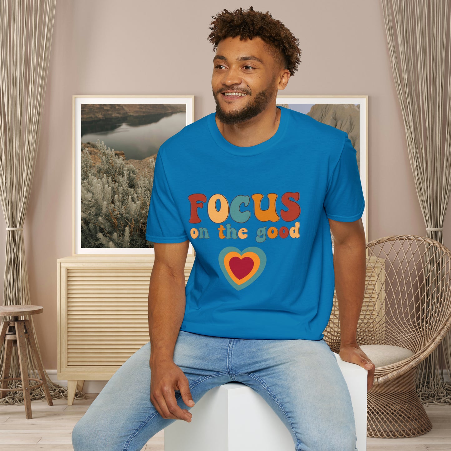 “FOCUS on the good” above a multicolored heart on this Unisex Softstyle T-Shirt.