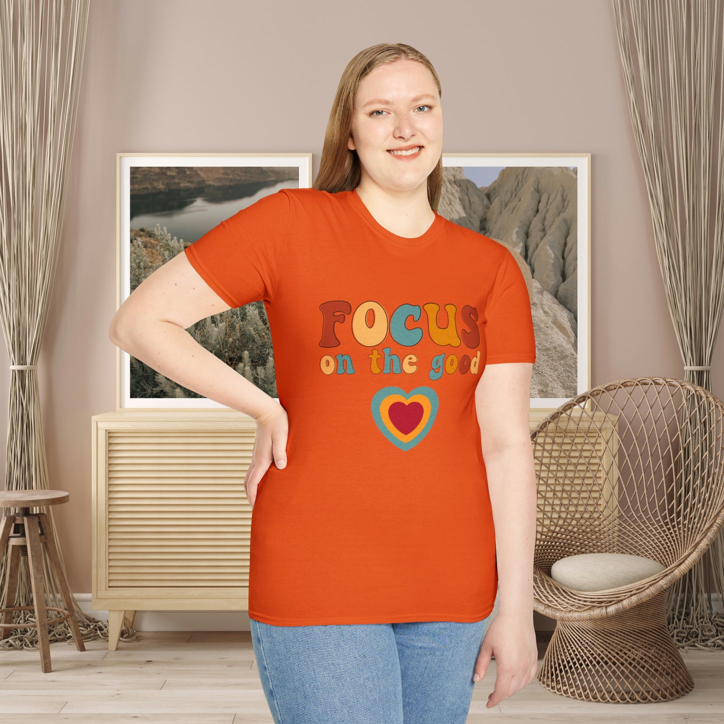 “FOCUS on the good” above a multicolored heart on this Unisex Softstyle T-Shirt.